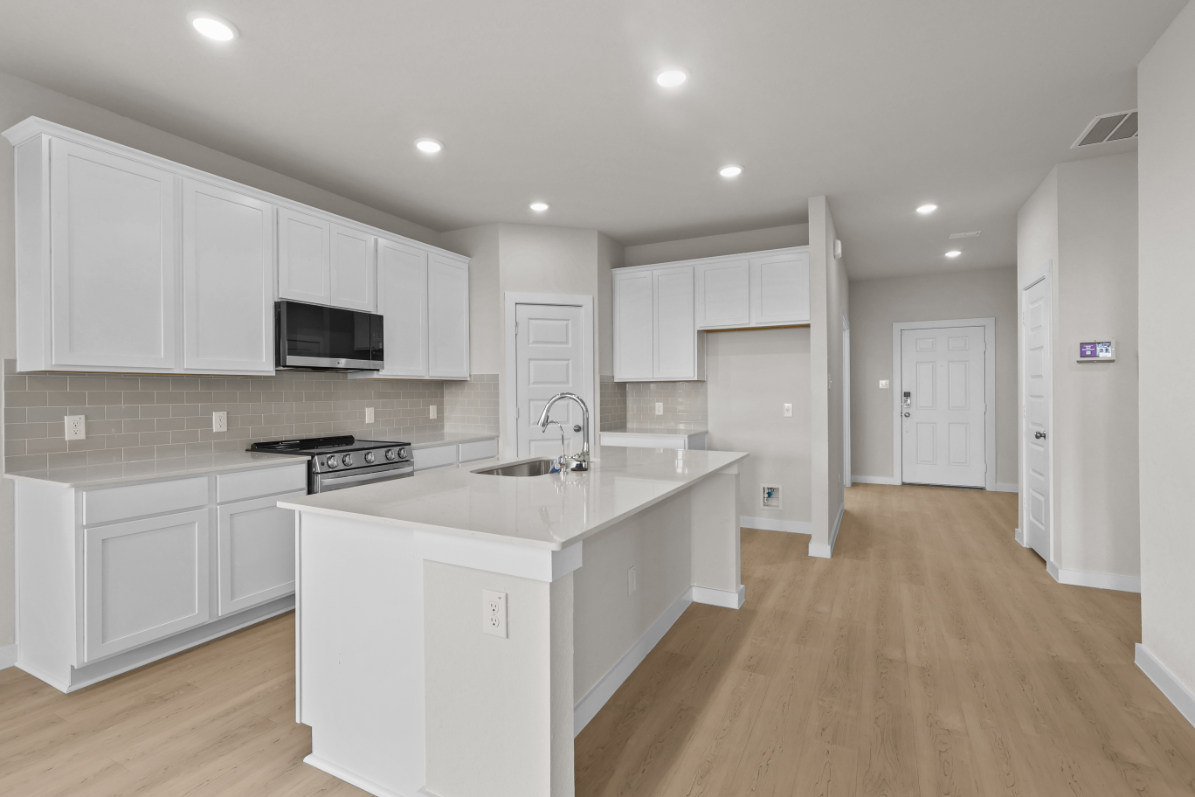 A kitchen with white cabinets.
