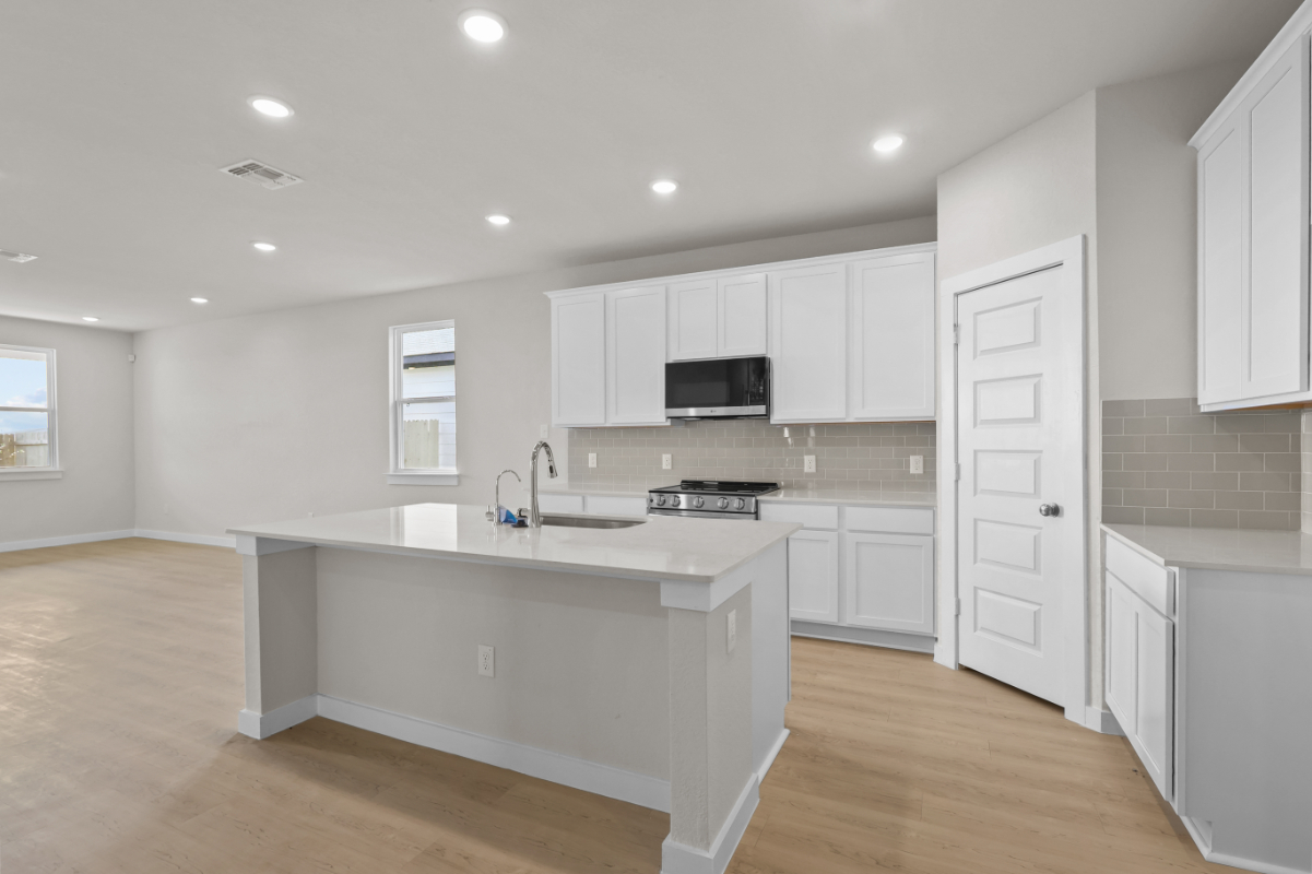 A kitchen with white cabinets.