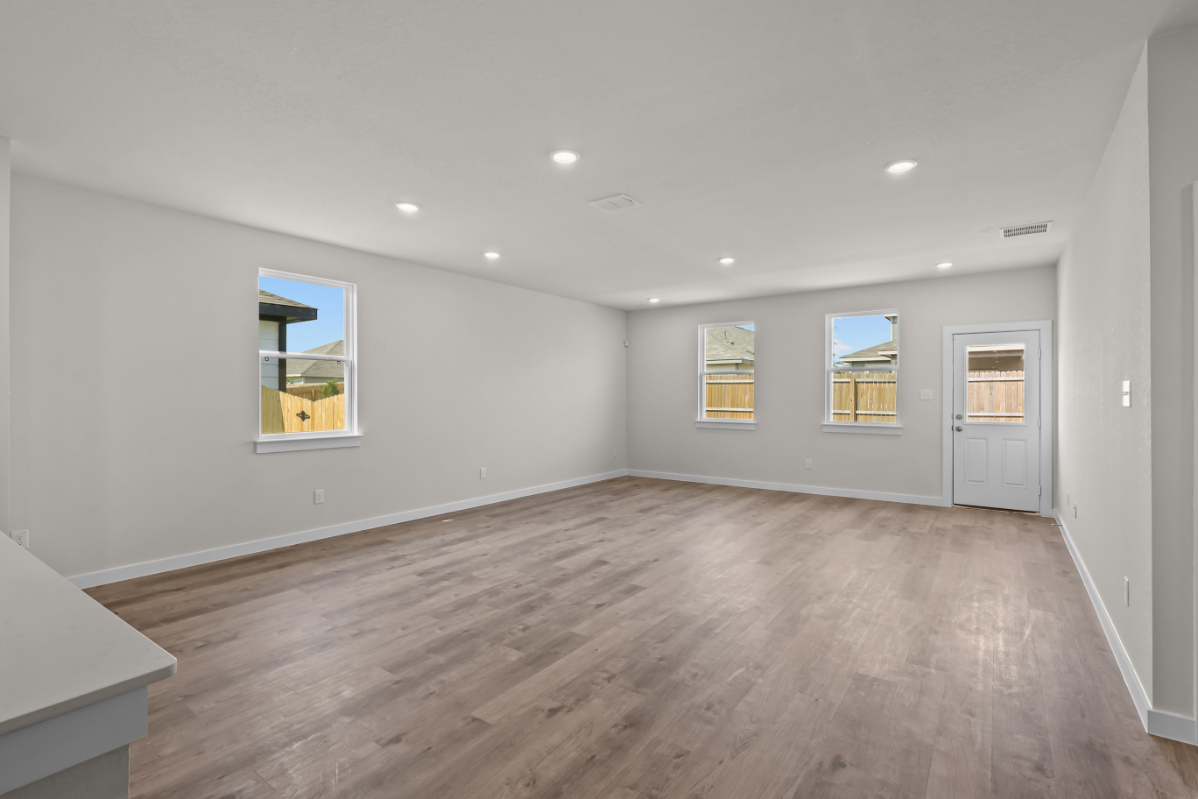 A room with a wood floor and windows.