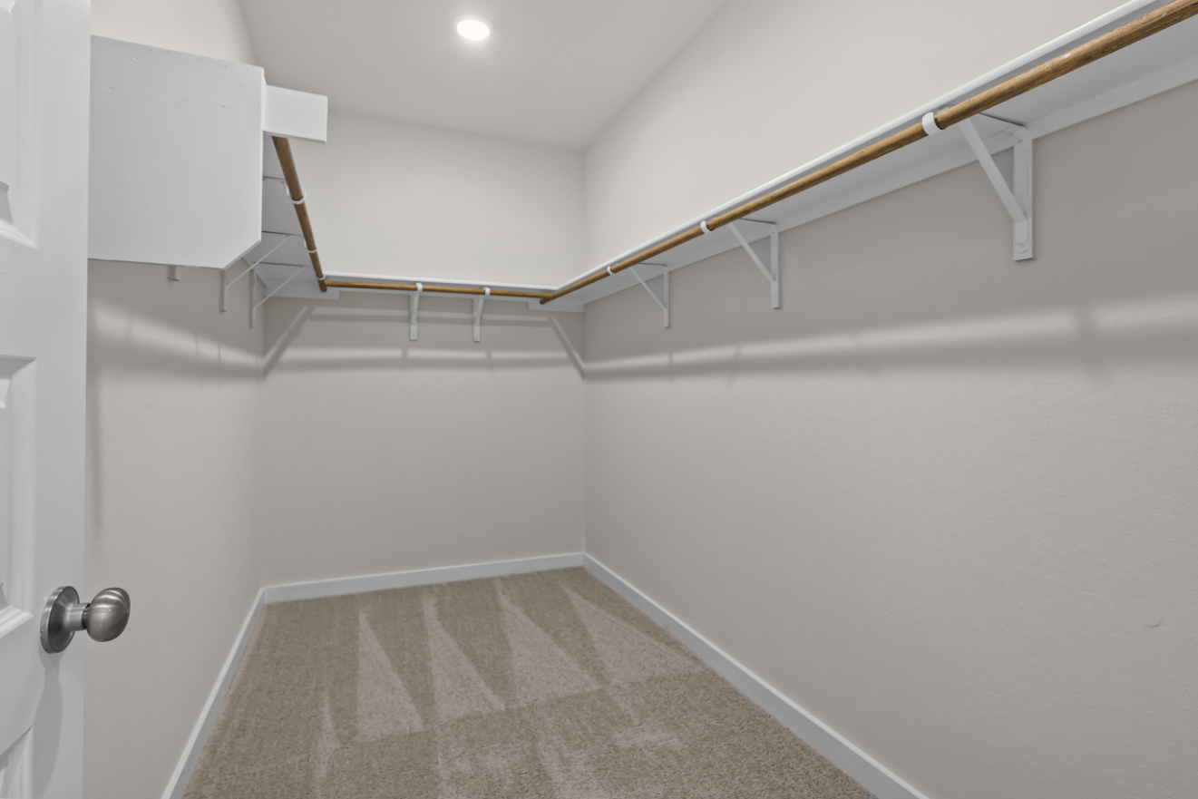 A white tiled room with a metal railing.