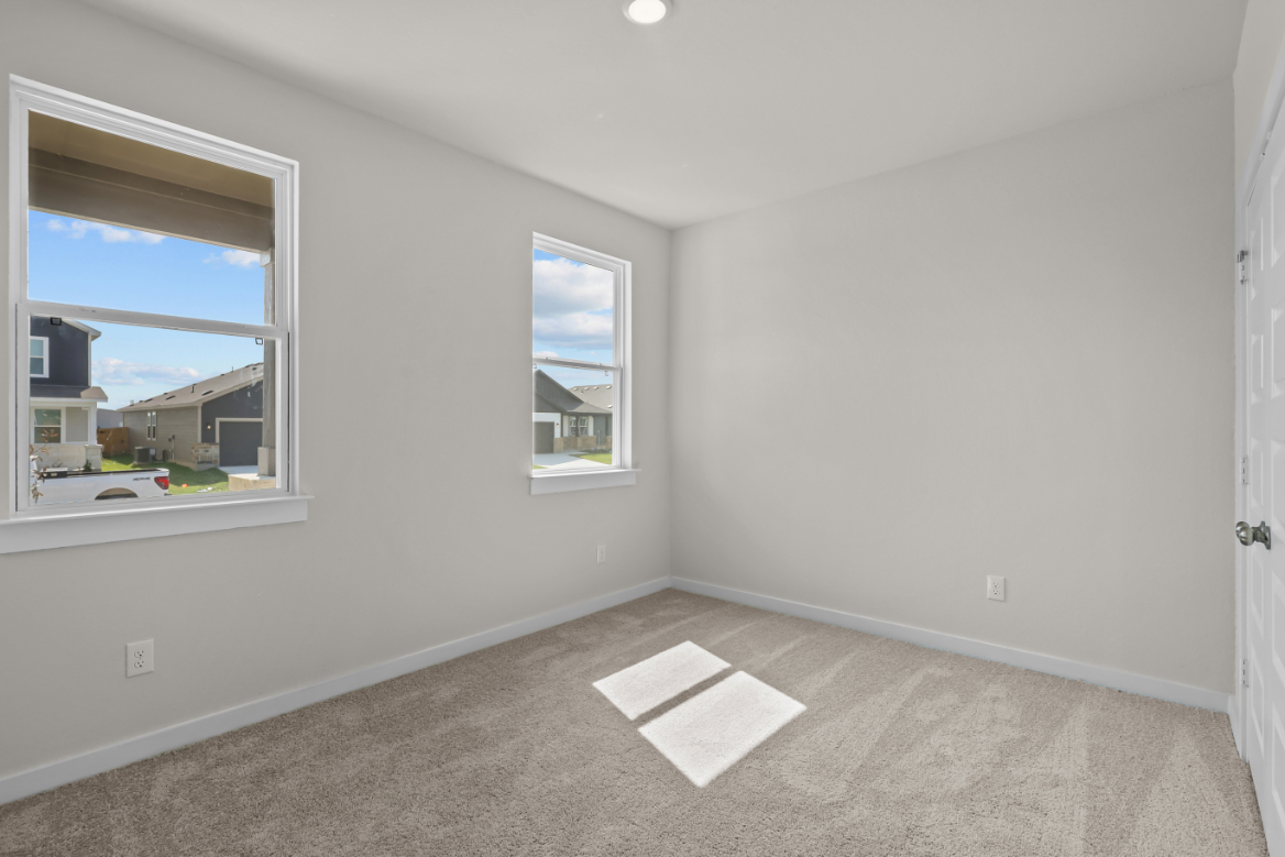 A room with a window and a rug in it.