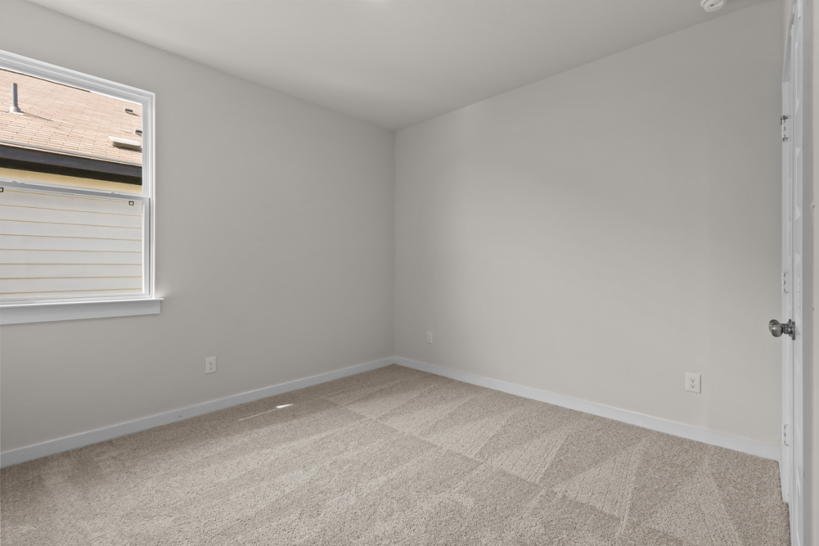A room with a carpet and a window.