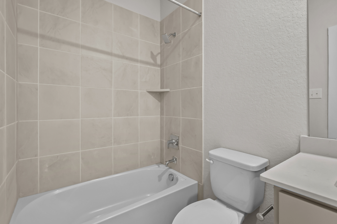 A bathroom with a toilet and bathtub.