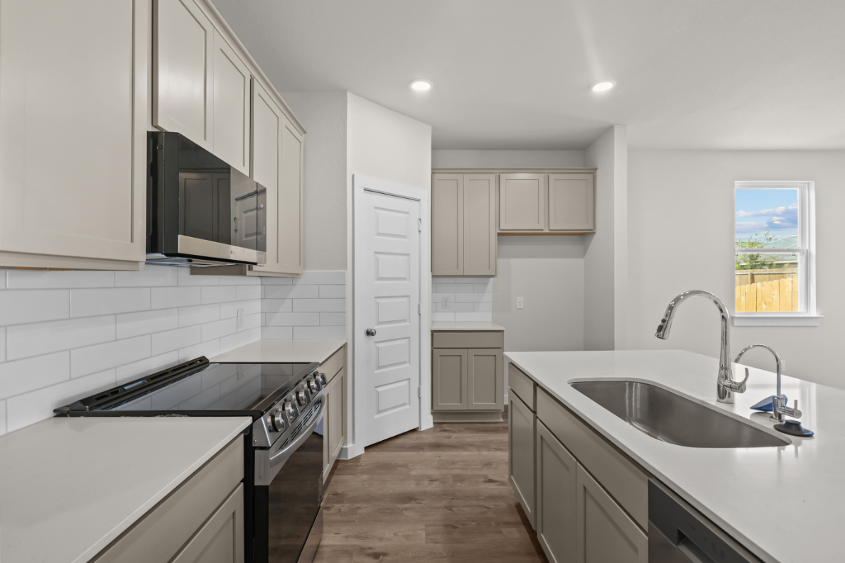 A kitchen with white cabinets.