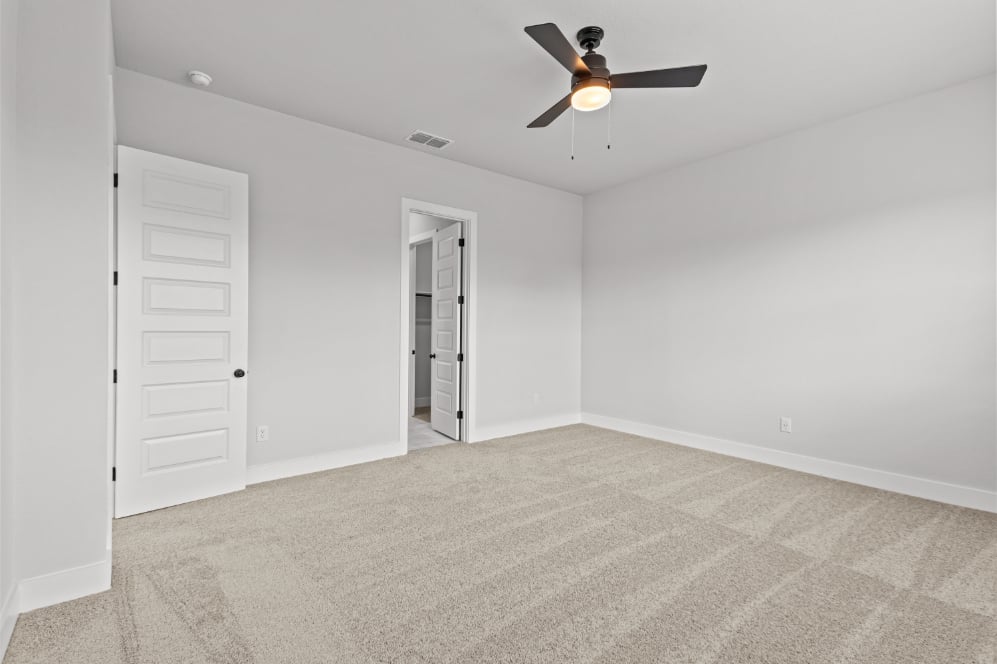 A room with a ceiling fan and a door.