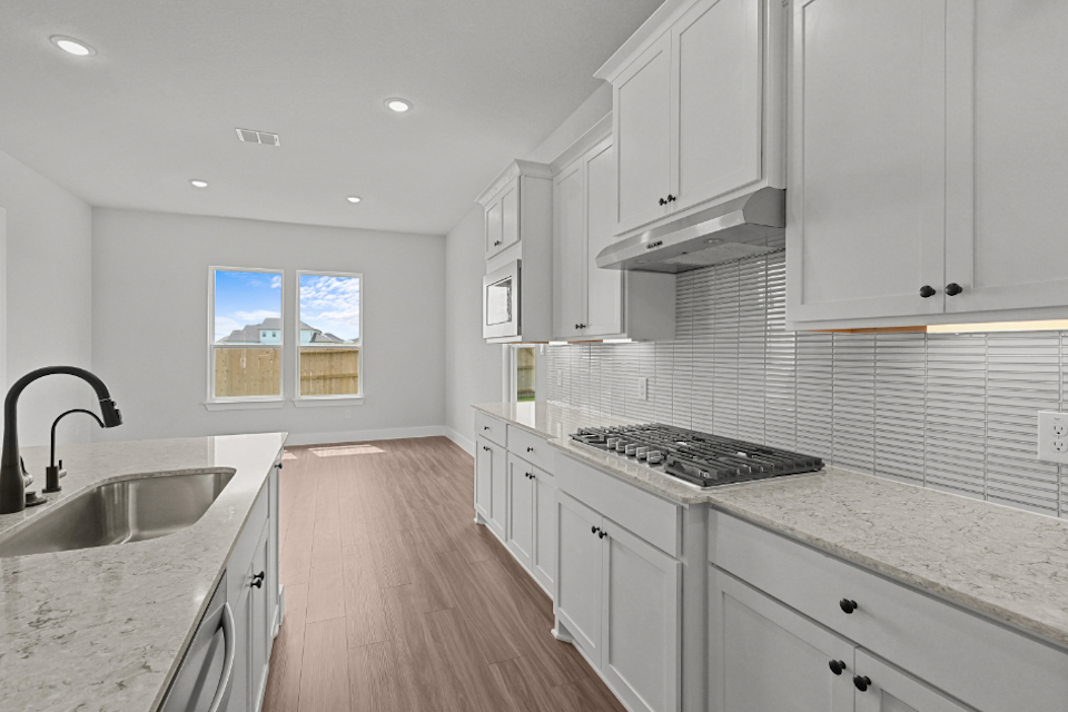A kitchen with white cabinets.