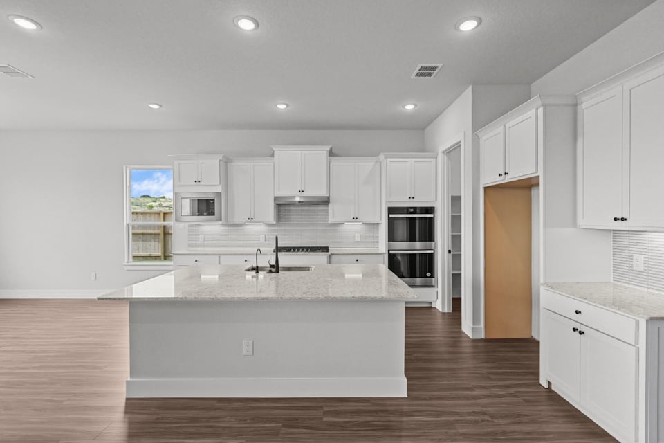 A kitchen with white cabinets.