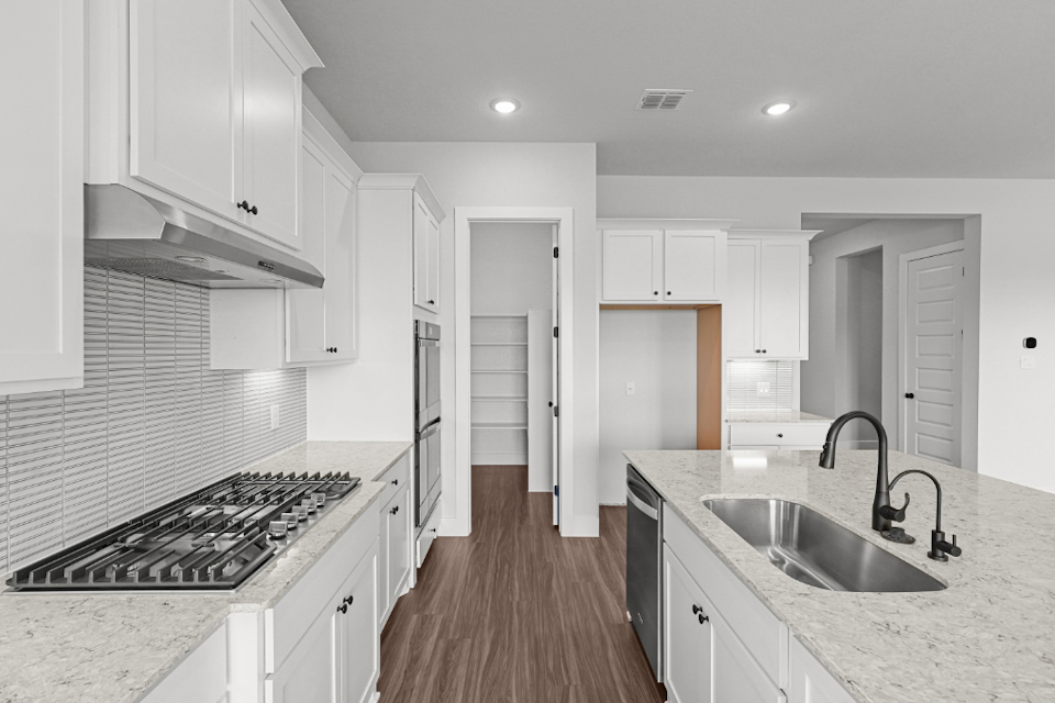 A kitchen with white cabinets.
