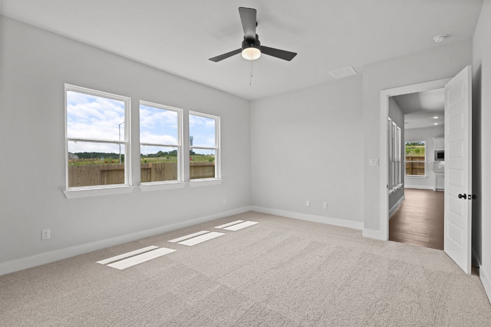 A room with a ceiling fan and a window.