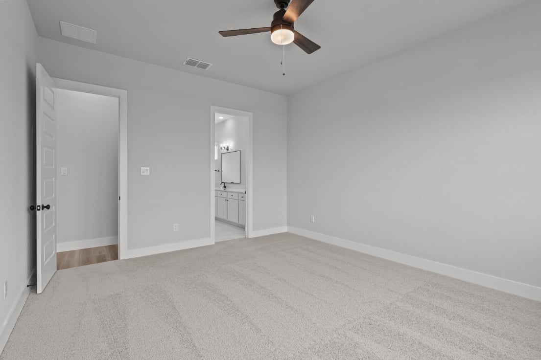 A room with a ceiling fan and a door.