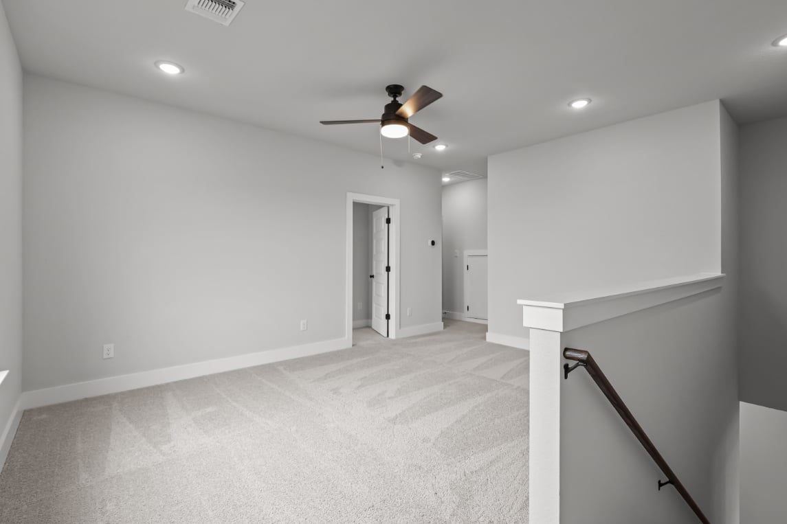 A room with white walls and a ceiling fan.