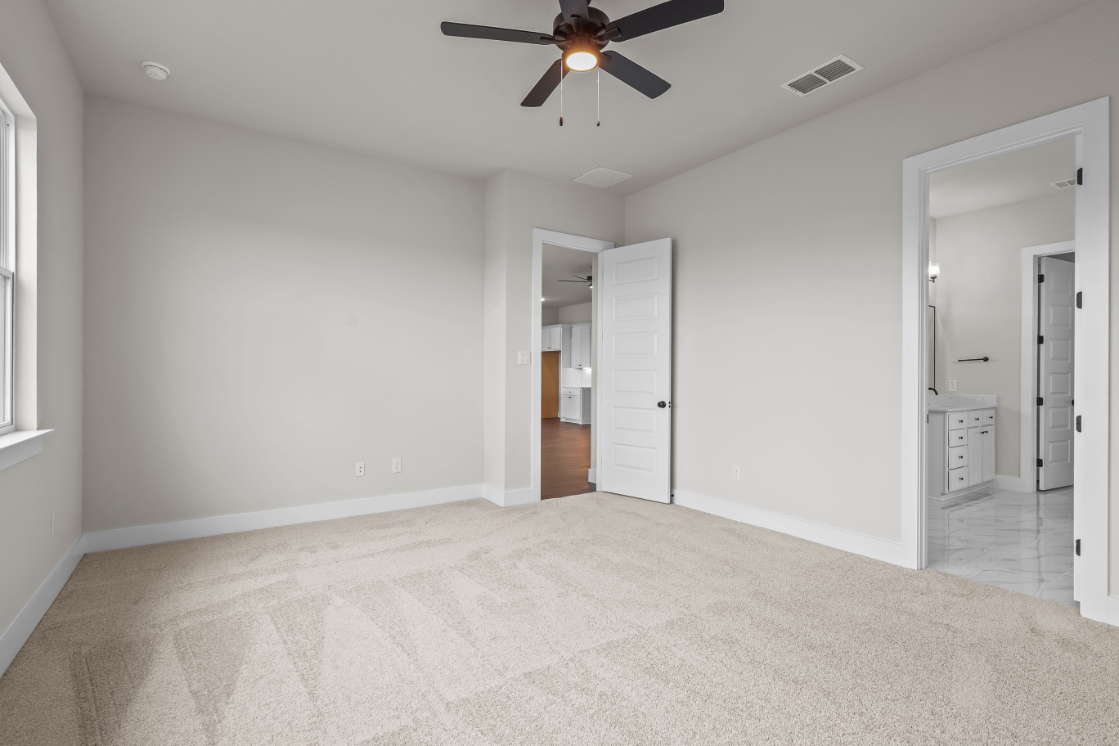 A room with a ceiling fan and a door.