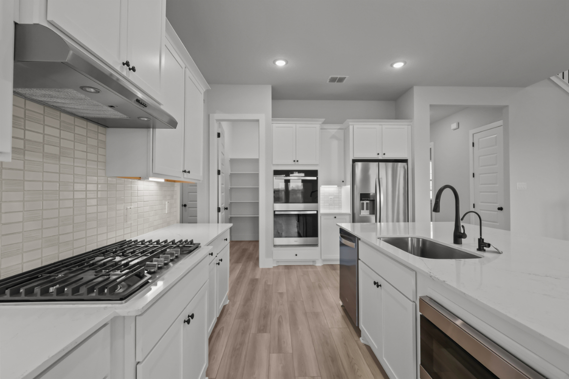 A kitchen with white cabinets.