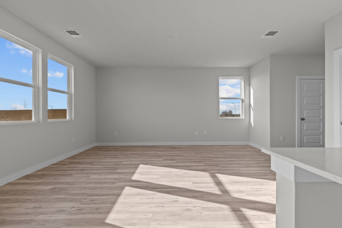 A room with windows and a wood floor.