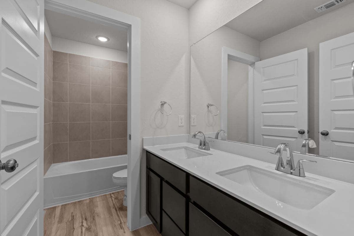A bathroom with a tub sink and toilet.