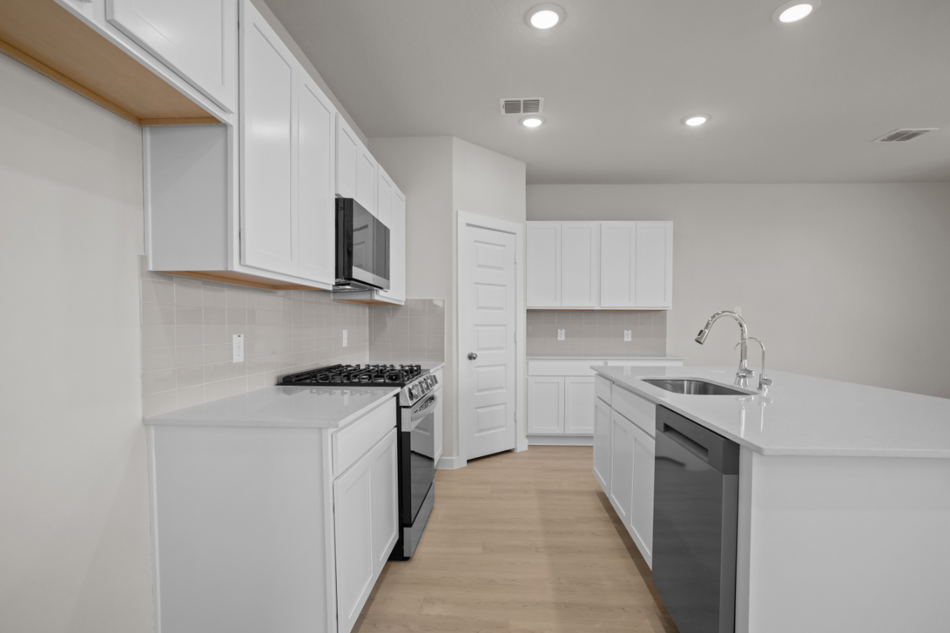 A kitchen with white cabinets.