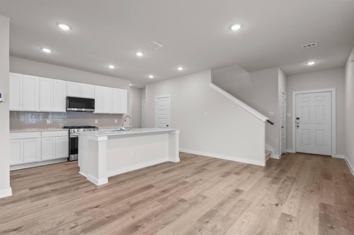 A kitchen with white cabinets.