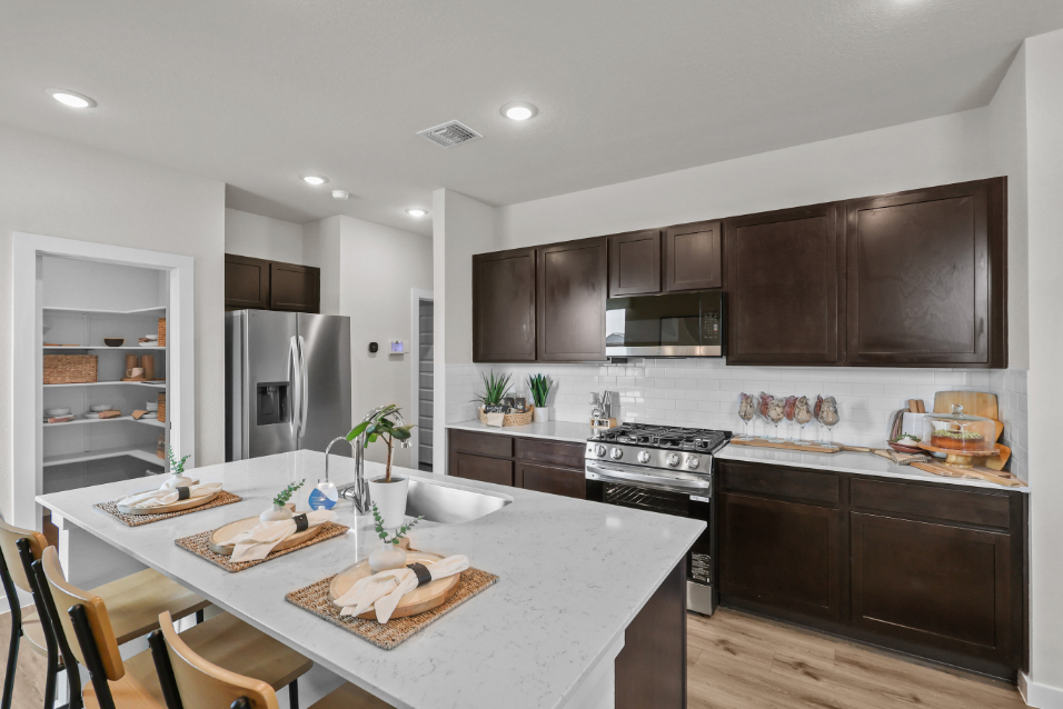 A kitchen with a table and chairs.