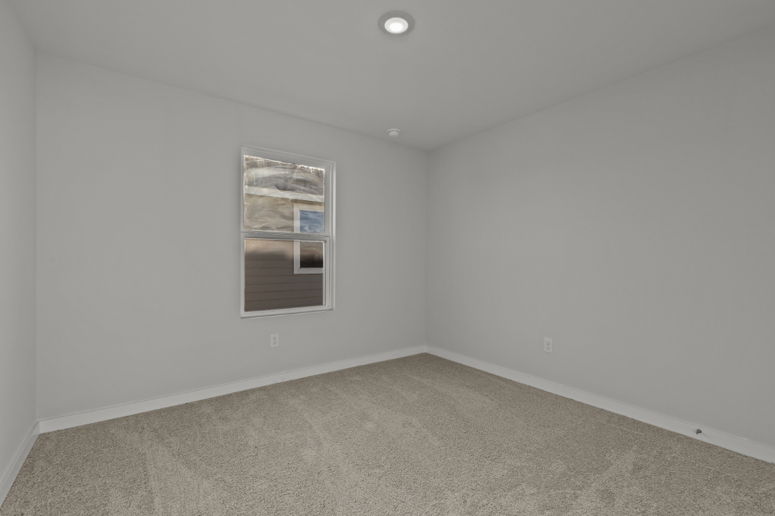 A room with a window and carpet.