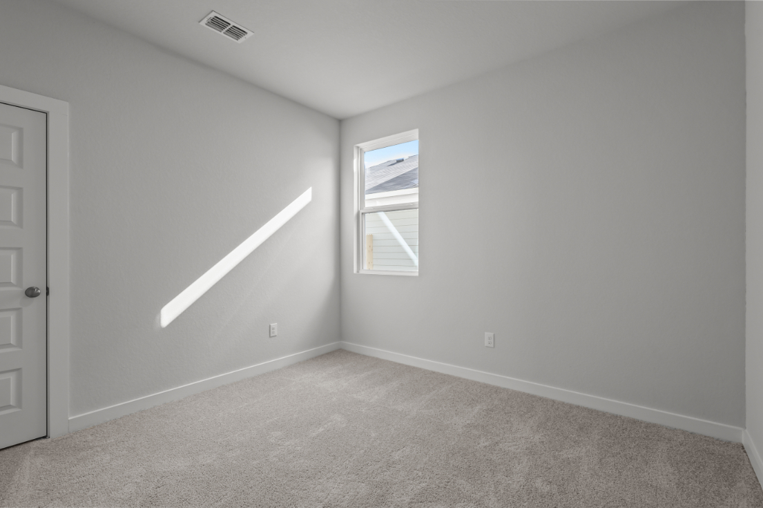 A room with a carpet and a door.