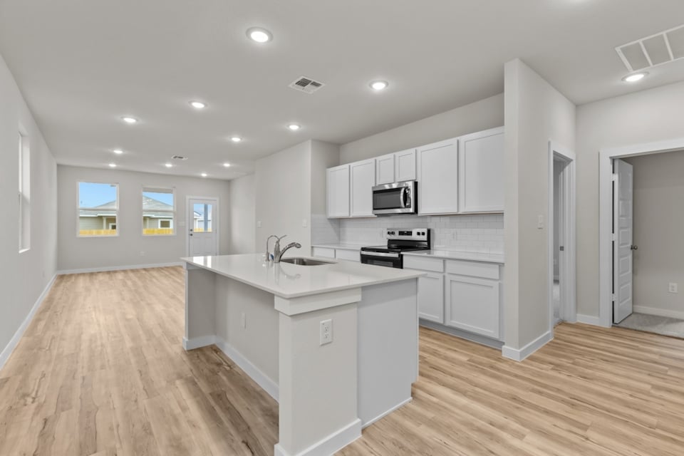A kitchen with white cabinets.