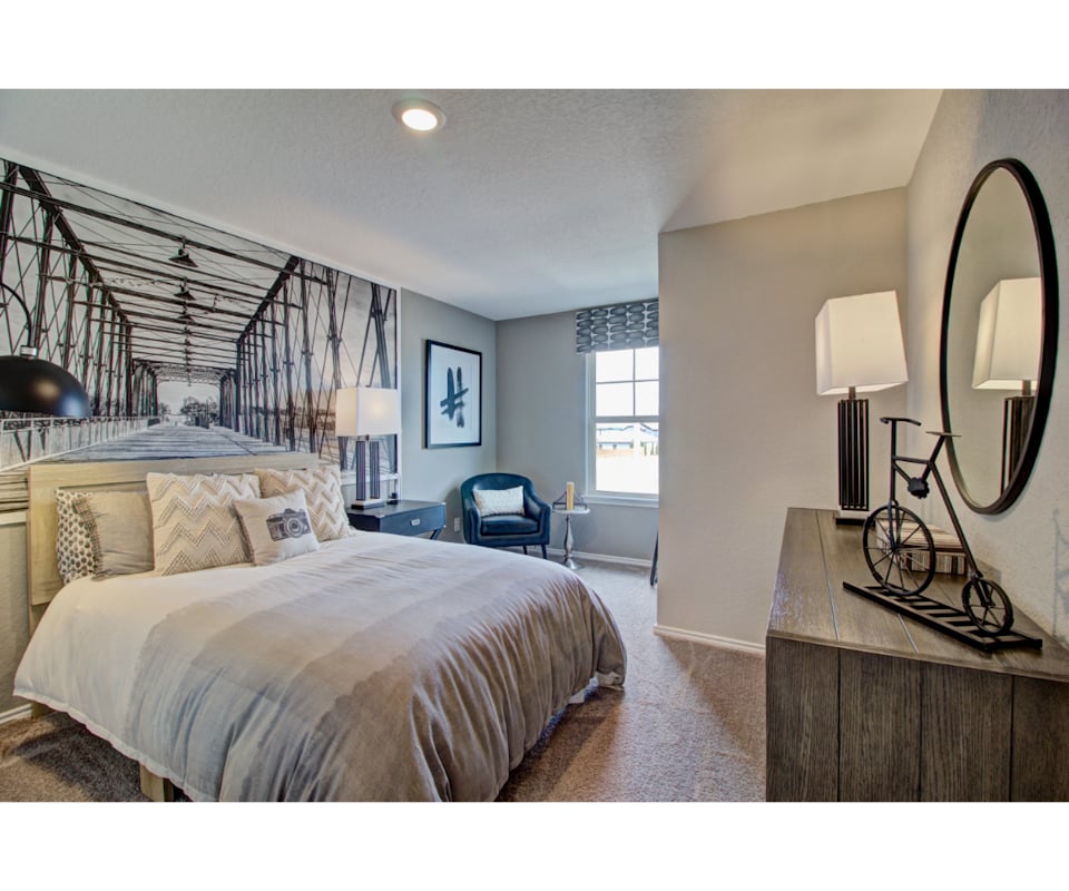 A bedroom with a bed and a mirror.