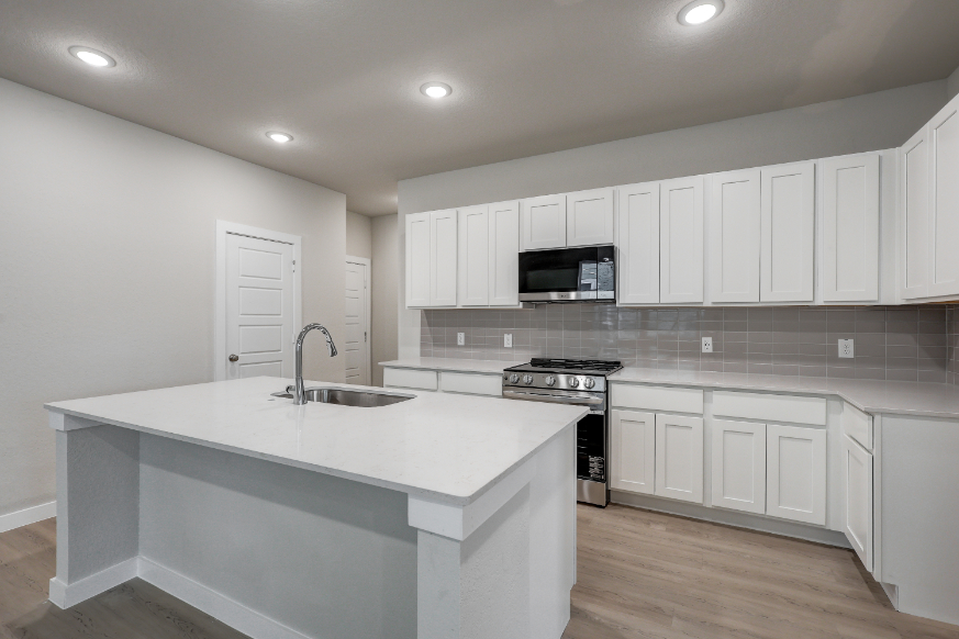 A kitchen with white cabinets.