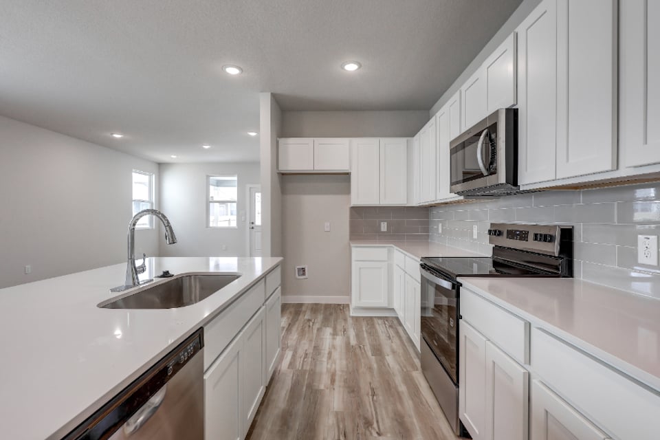A kitchen with white cabinets.