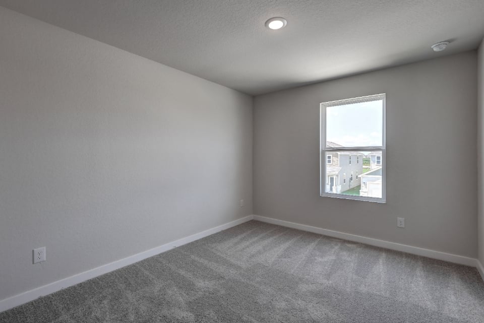 A room with a window and a carpet.