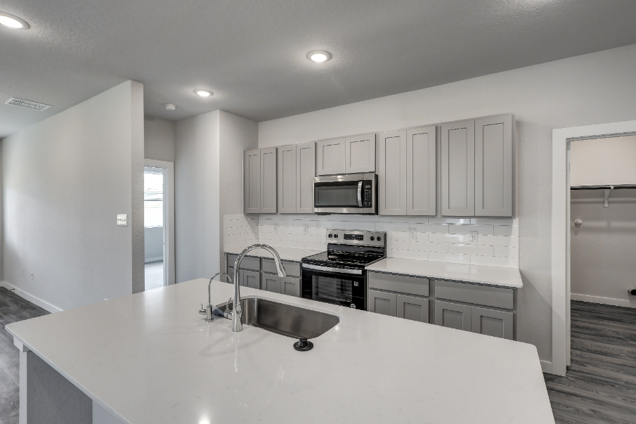 A kitchen with white cabinets.