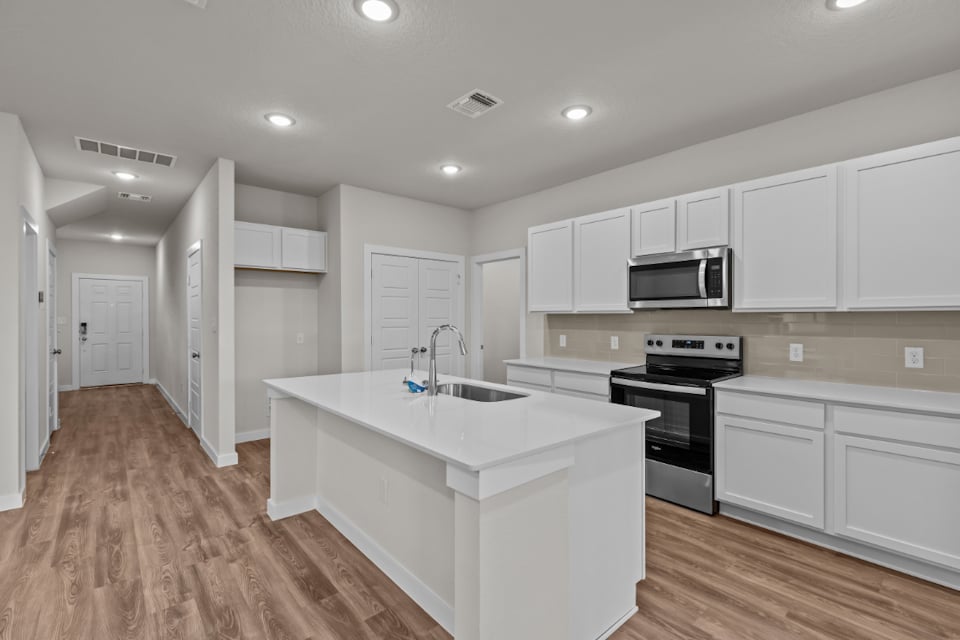 A kitchen with white cabinets.