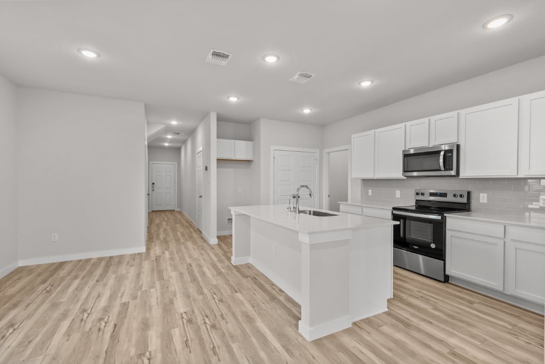 A kitchen with white cabinets.