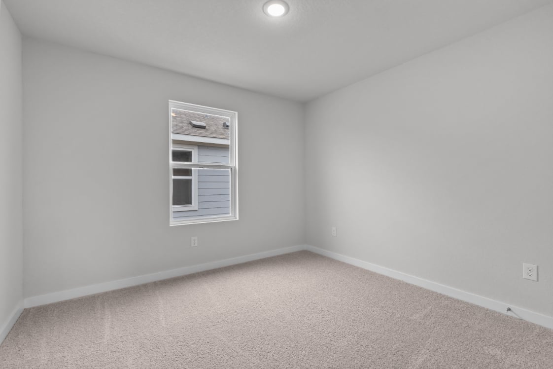 A room with a window and a carpet.