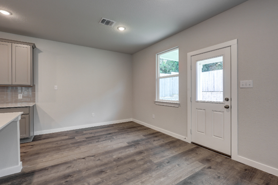 A room with a wood floor and a white door.