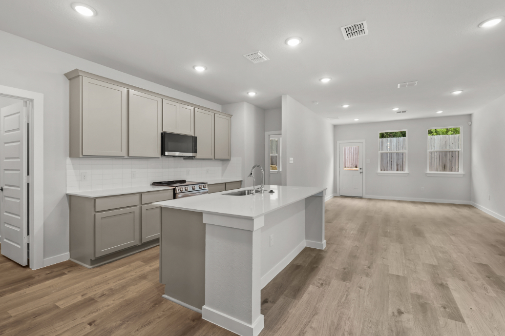 A kitchen with white cabinets.
