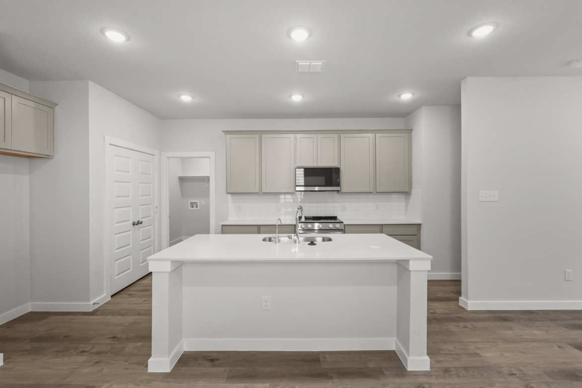 A kitchen with white cabinets.