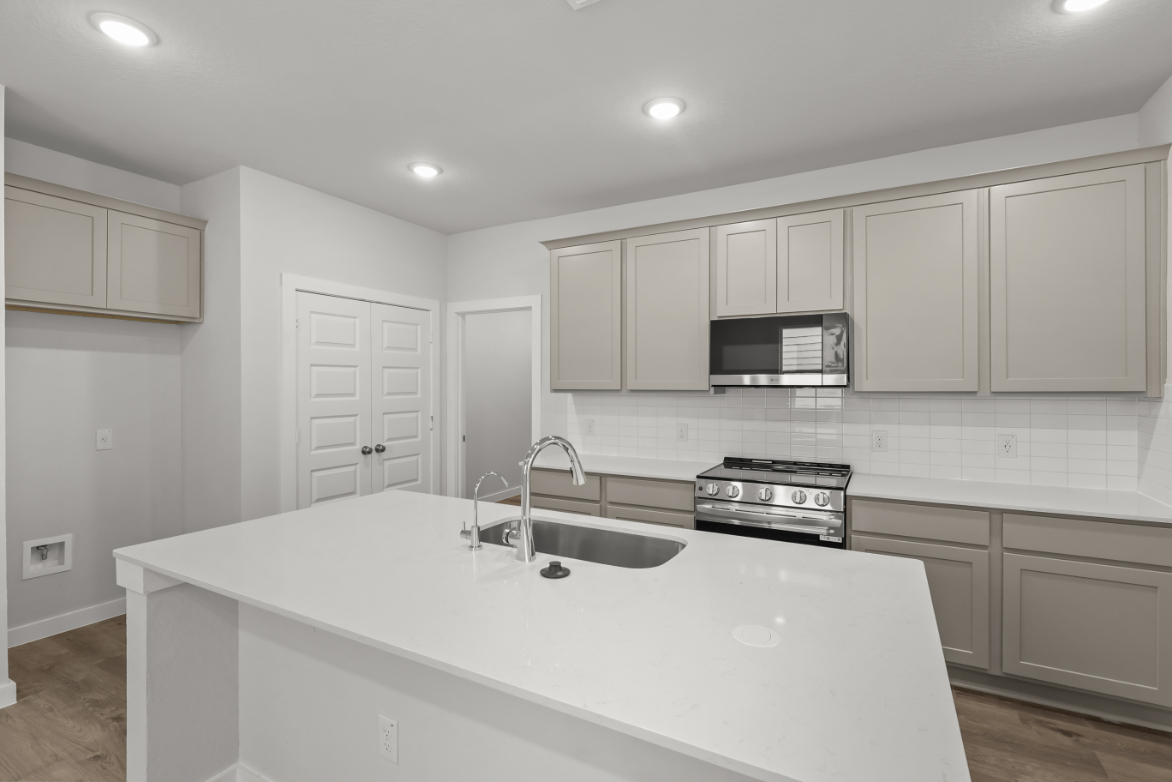 A kitchen with white cabinets.