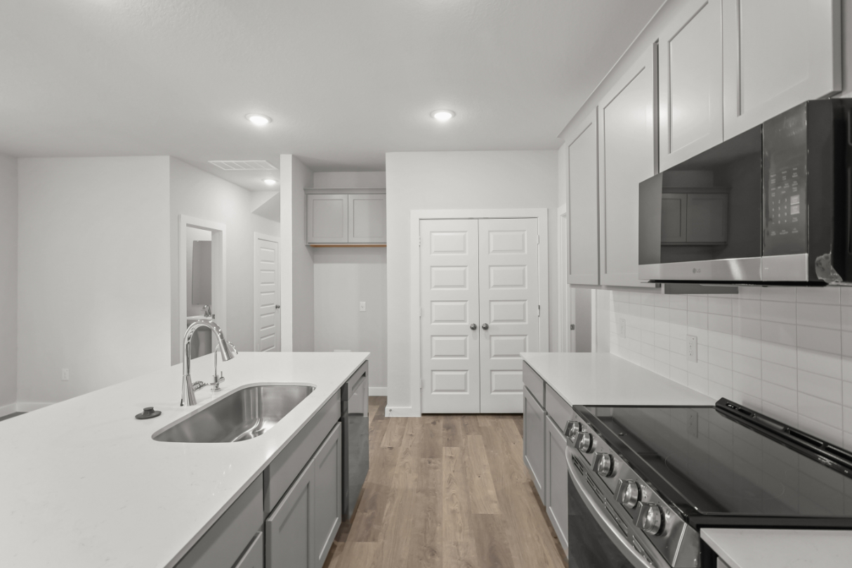 A kitchen with white cabinets.