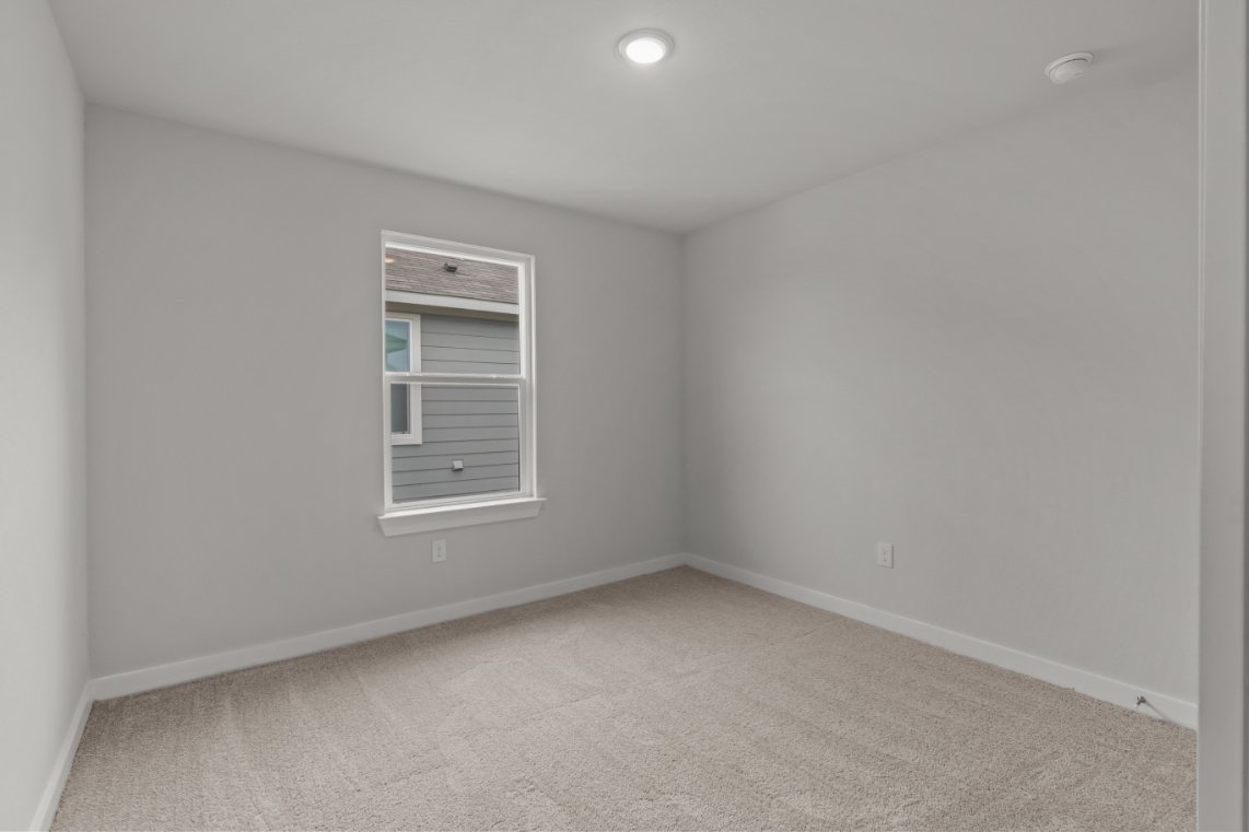 A room with a window and carpet.