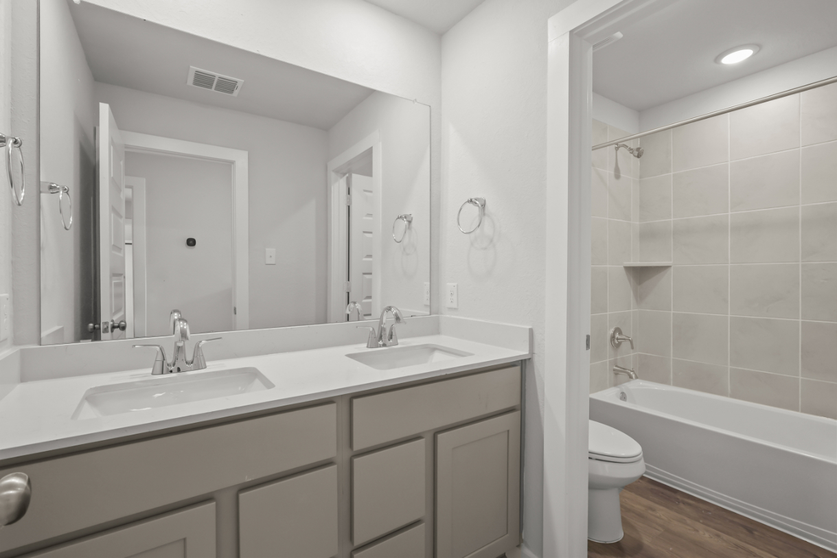 A bathroom with a tub sink and toilet.