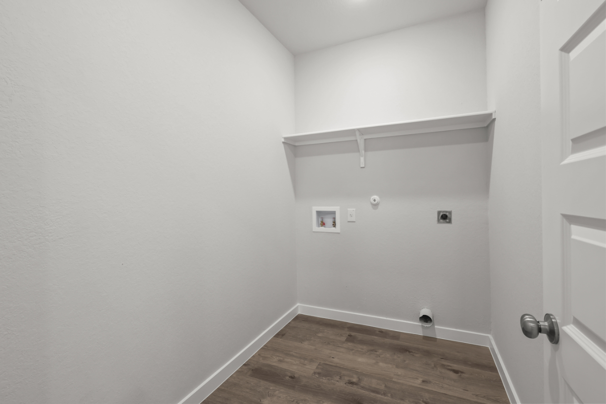 A white room with a wood floor.