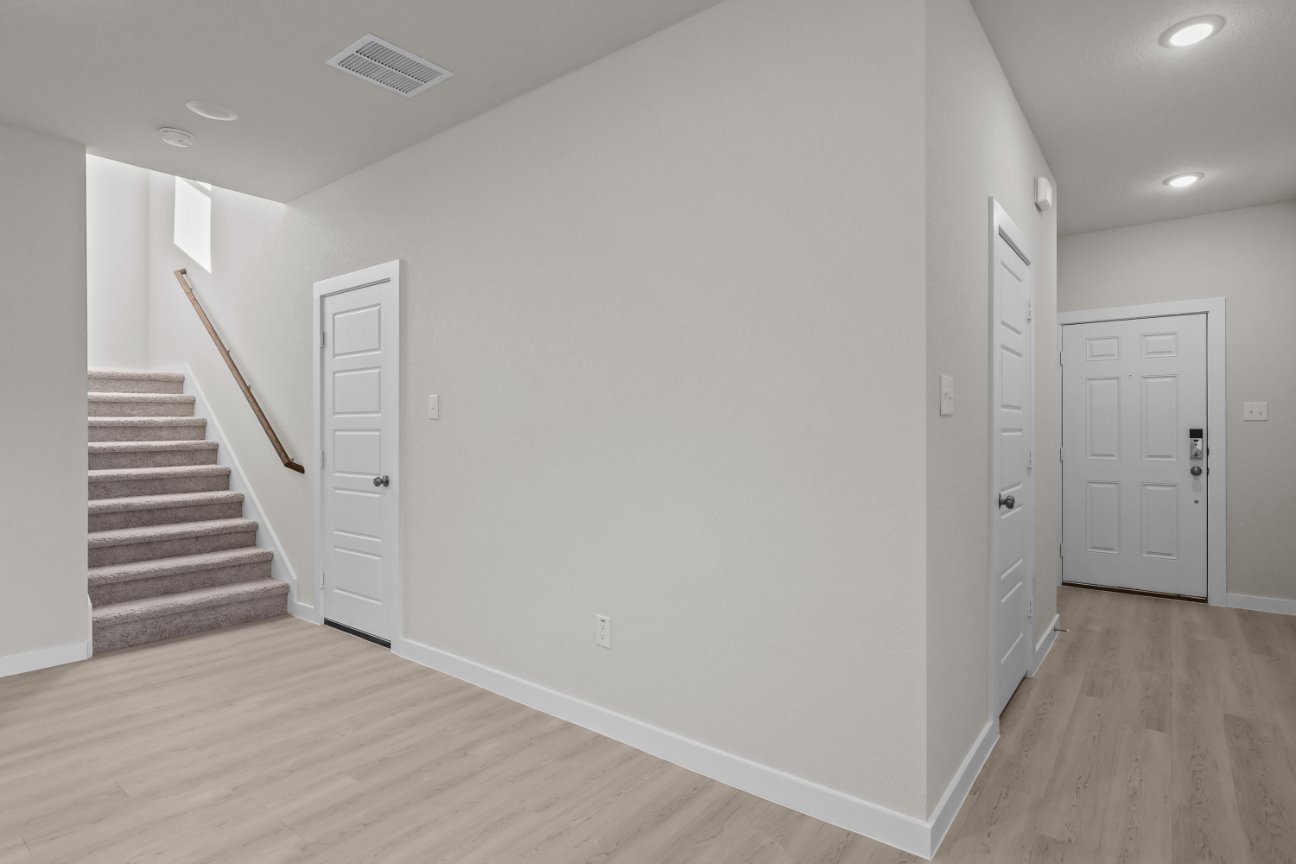 A white hallway with white doors.