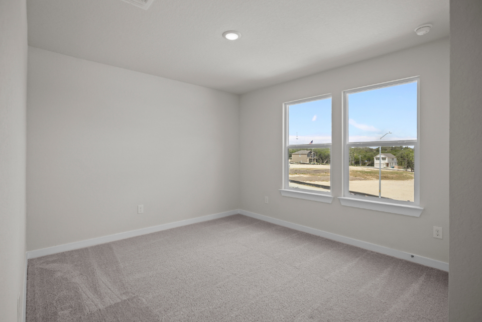 A room with a carpet and windows.
