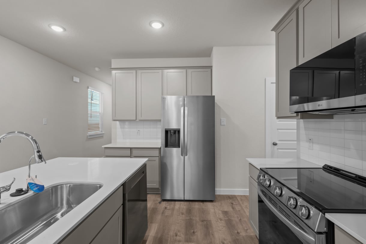 A kitchen with white cabinets.