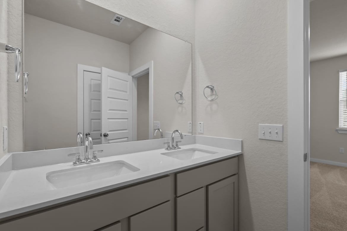 A bathroom with a large mirror.