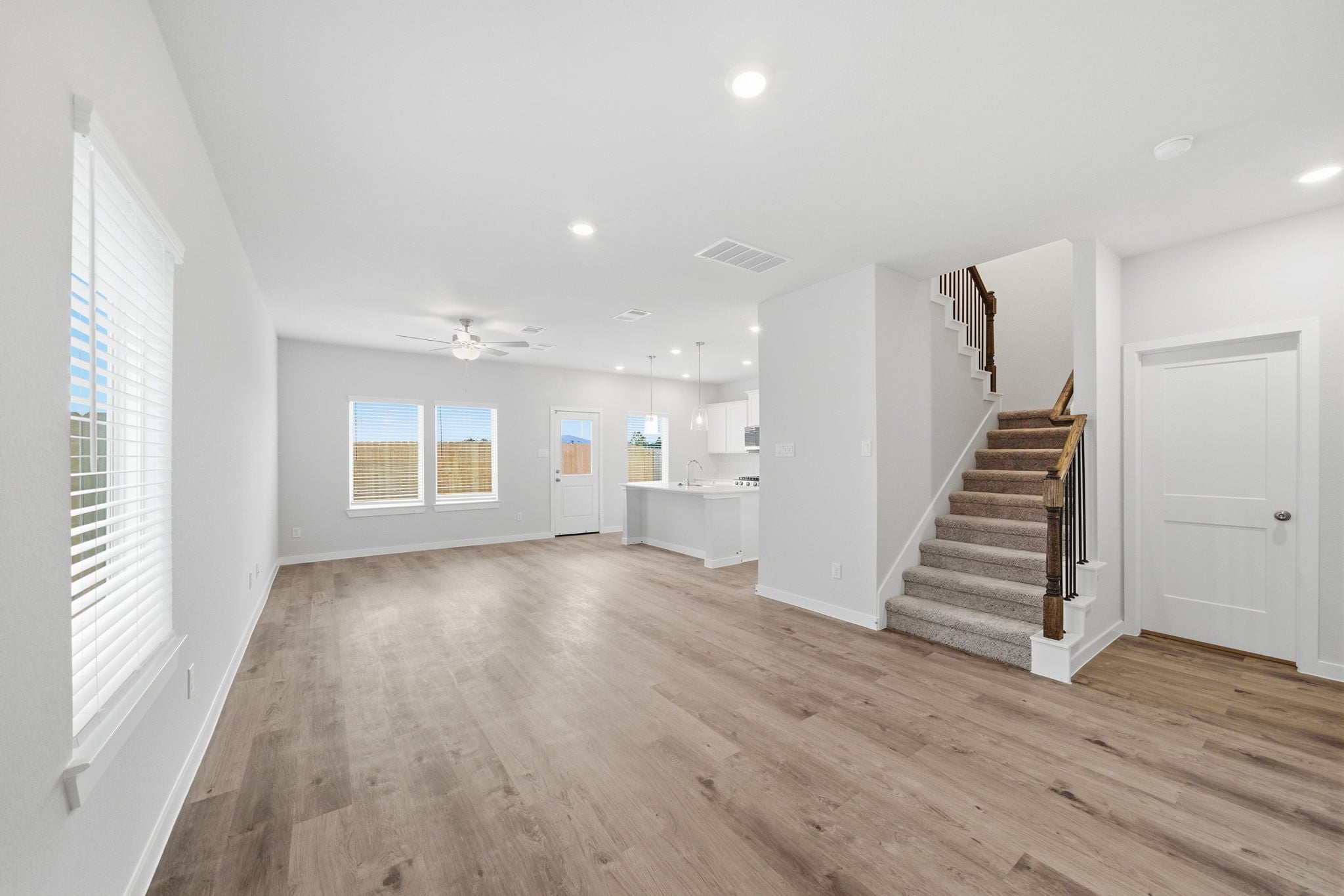A large empty room with a wood floor and white walls.