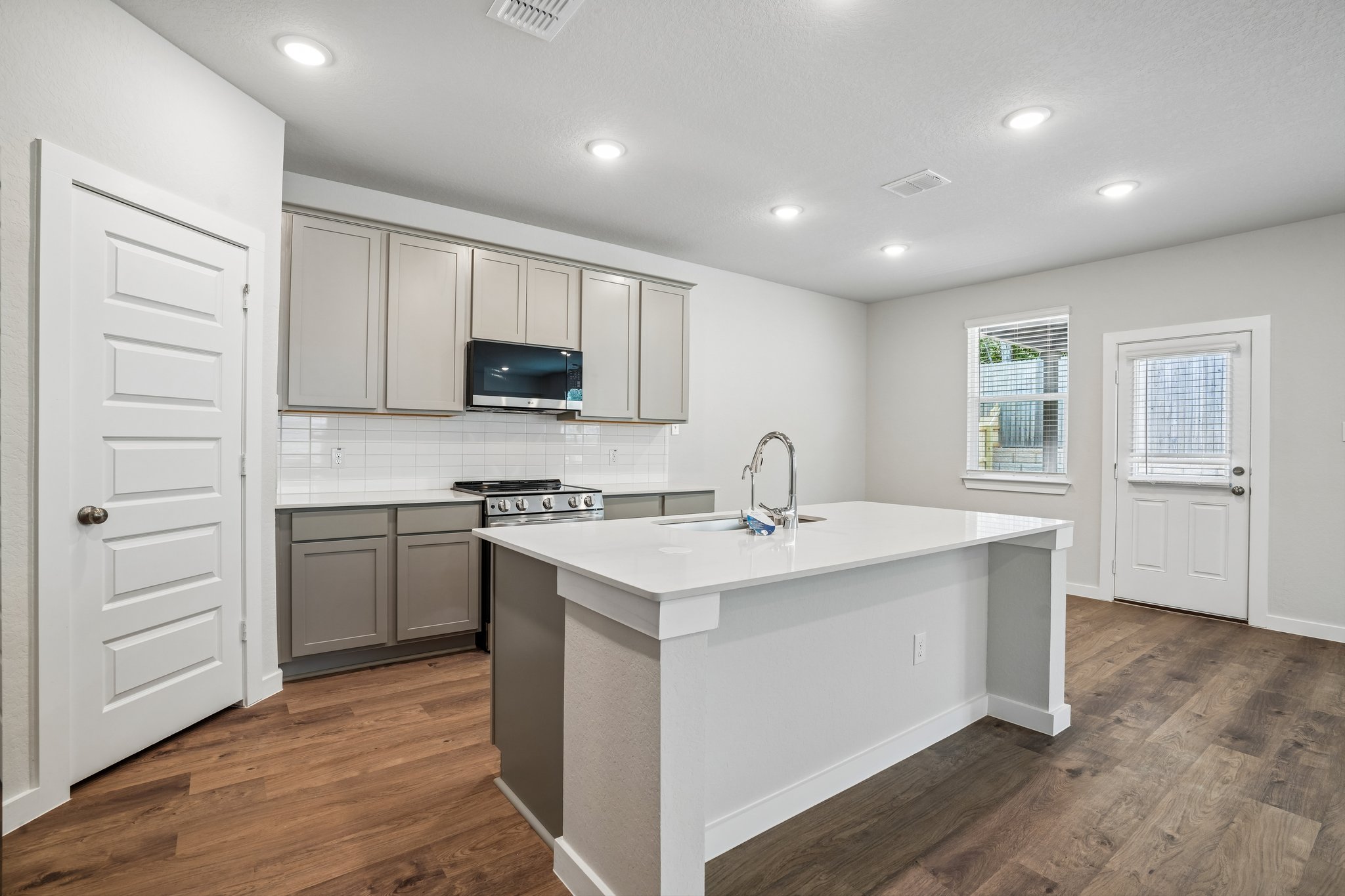 A kitchen with white cabinets.