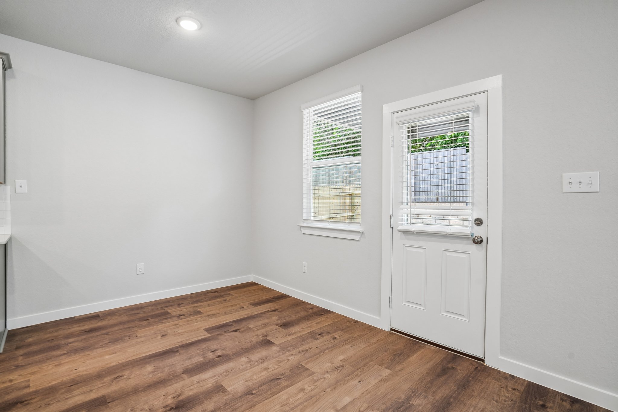 A room with white walls and wood floors.