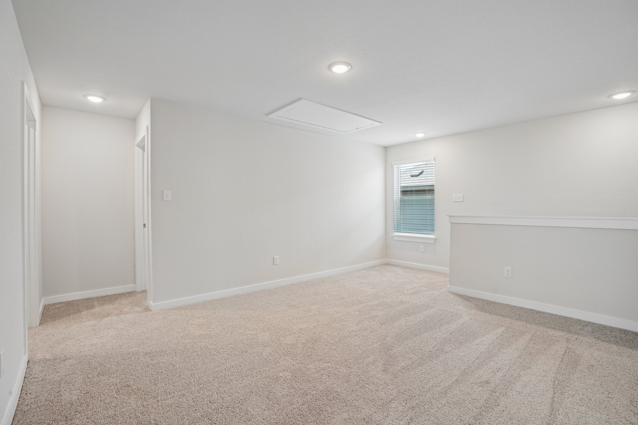 A room with a carpet and a window.
