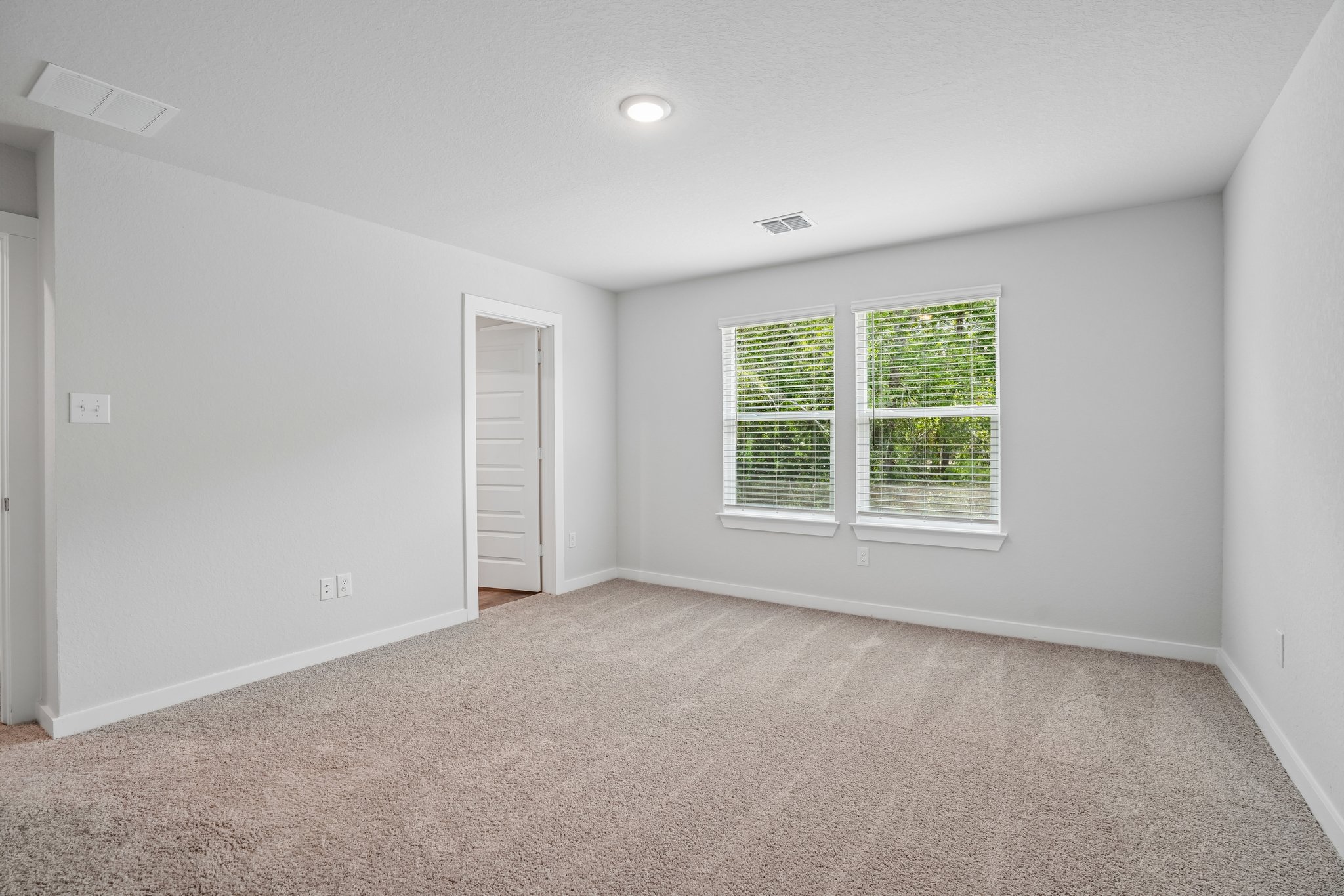 A room with a carpet and a door.